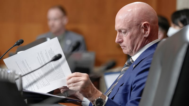 Sen. Mark Kelly, D-Ariz., reads documents during a hearing of the Senate Environment and...