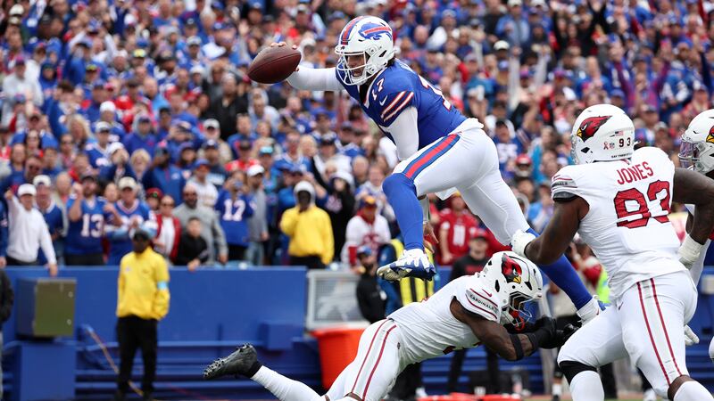 Buffalo Bills quarterback Josh Allen (17) leaps over Arizona Cardinals safety Budda Baker for...