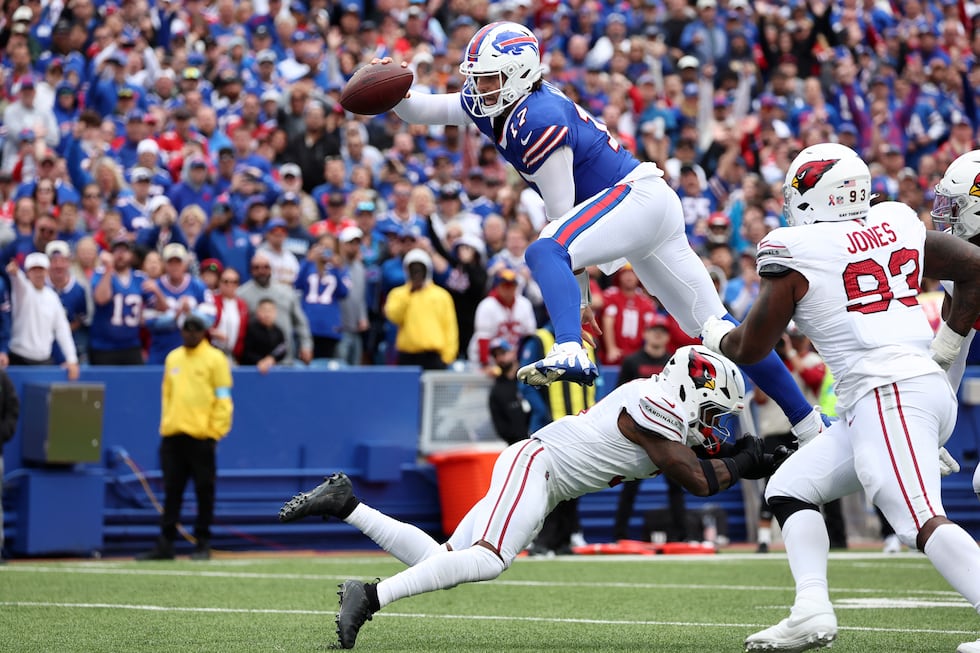 Buffalo Bills quarterback Josh Allen (17) leaps over Arizona Cardinals safety Budda Baker for...