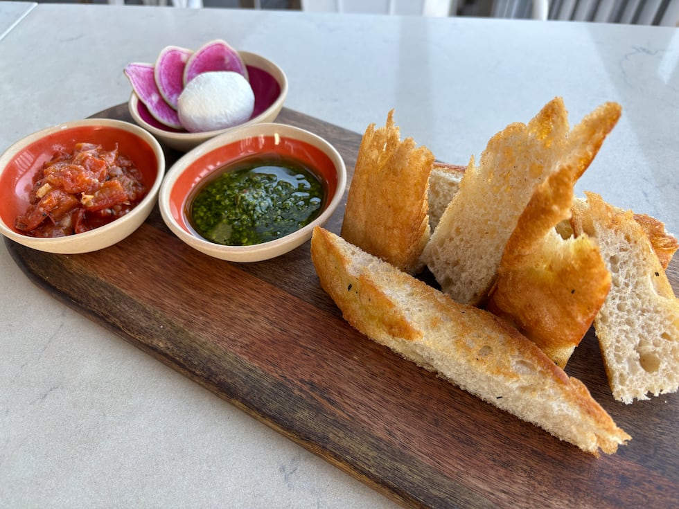 The "Take off Trio" is a happy hour bite served with focaccia bread, pesto, goat cheese, and...