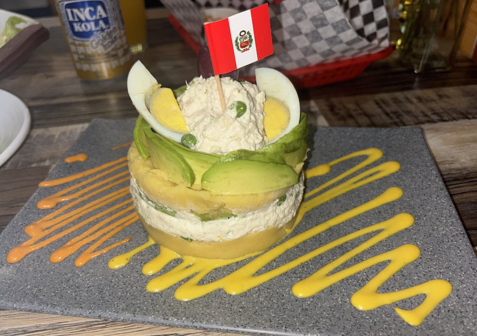 "Causa Limeña" made with layers of mashed potato, chicken salad and avocado. Topped with a...
