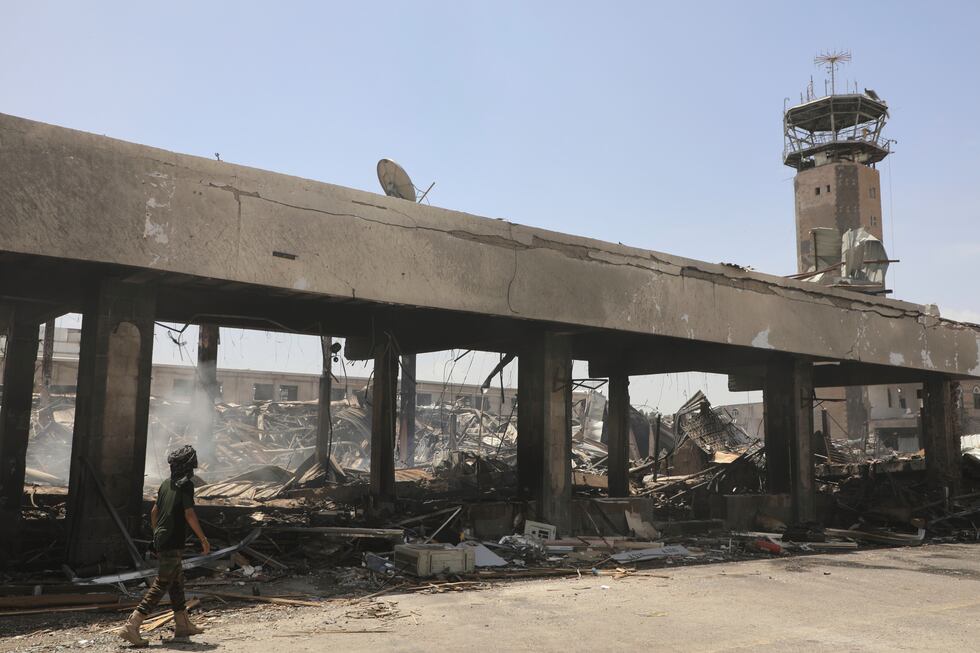 A Yemeni officer inspects the damage following Israeli airstrikes on Sanaa International...