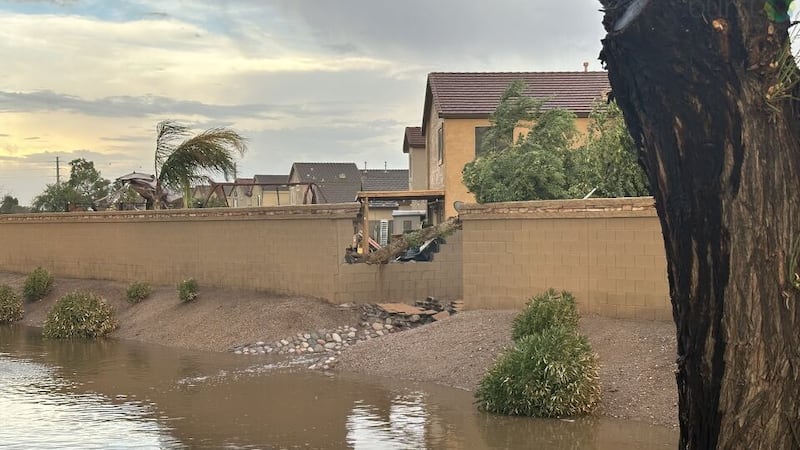 Flooded street and broken cement wall.