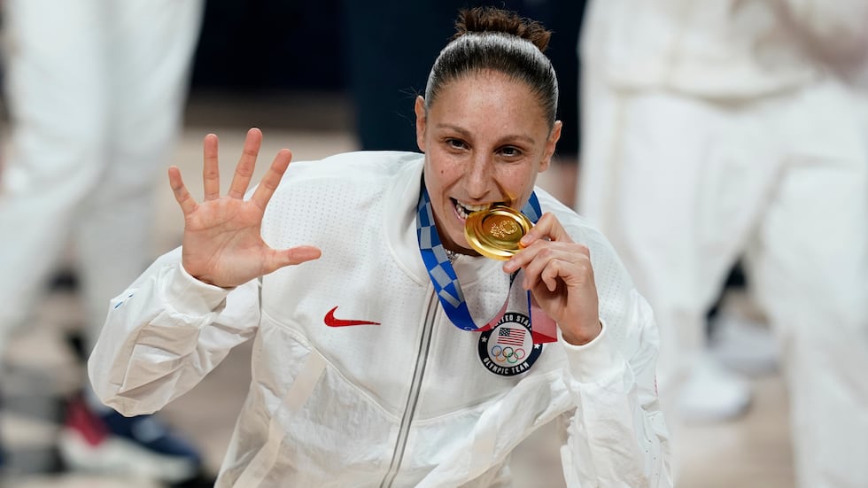 FILE - United States's Diana Taurasi bites her gold medal during the medal ceremony for...