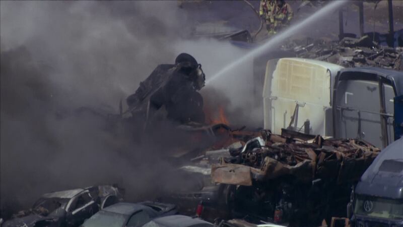 Phoenix firefighters battled a first-alarm fire at an automotive scrapyard late Tuesday morning.