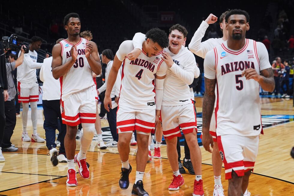 Arizona players, including forward Tobe Awaka (30), forward Trey Townsend (4) and guard KJ...