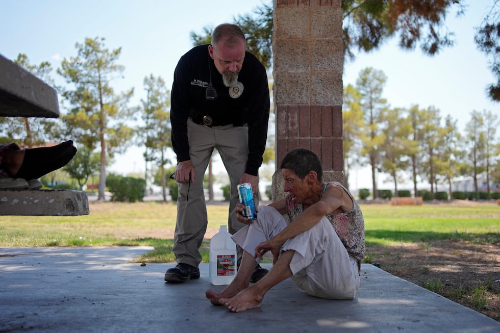 Mark Paulson, a Public Response and Code Enforcement officer, checks on Deb Billet, 66, before...