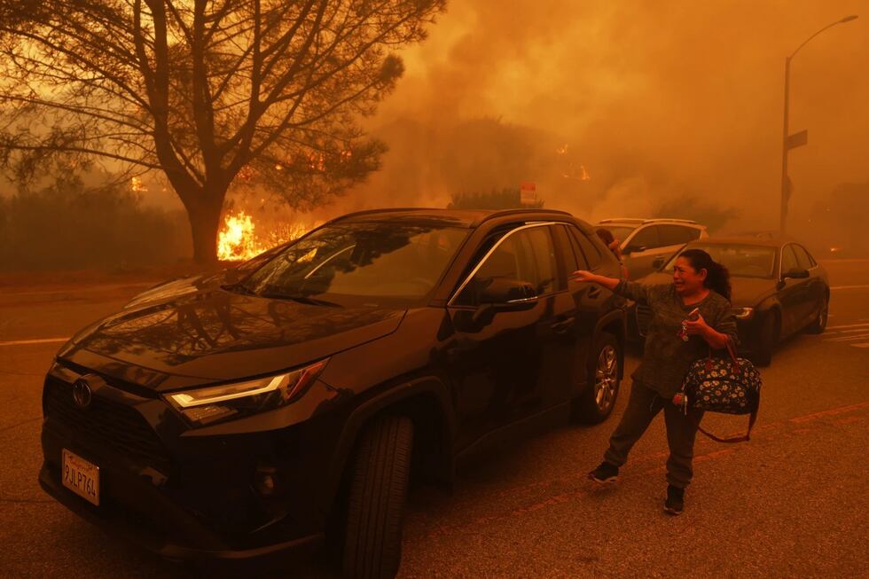 A woman cries as the Palisades Fire advances in the Pacific Palisades neighborhood of Los...