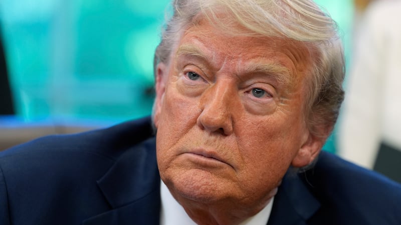 President Donald Trump speaks with reporters after signing executive orders in the Oval Office...