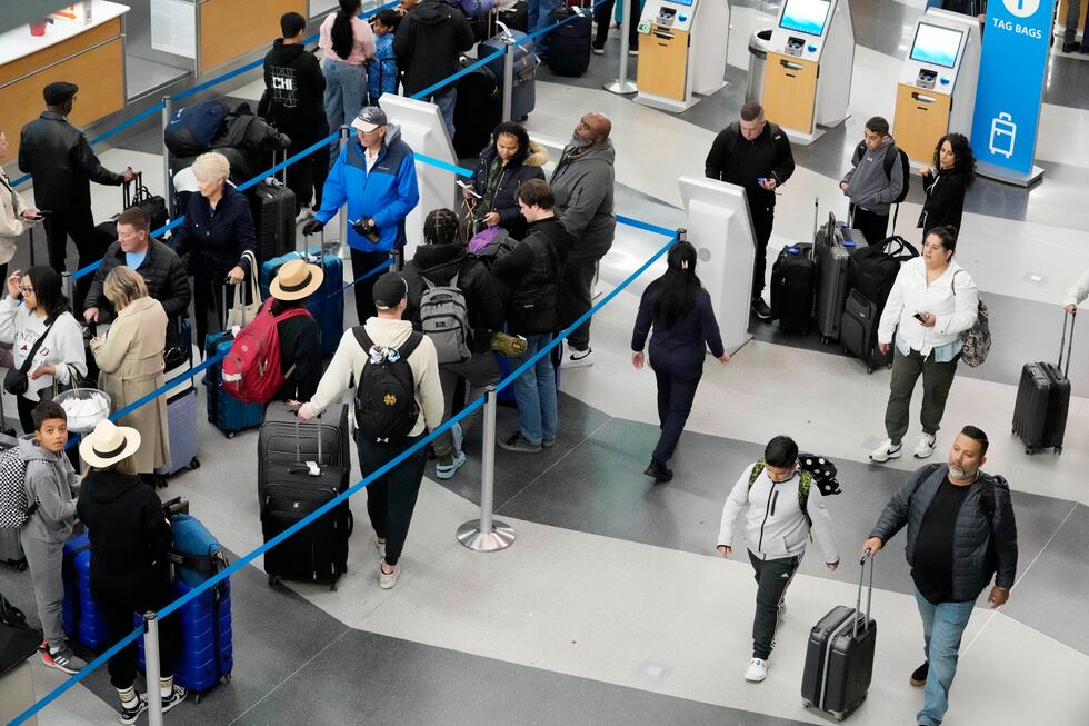 Travelers wait to drop off their bags and walk through Terminal 3 at O'Hare International...