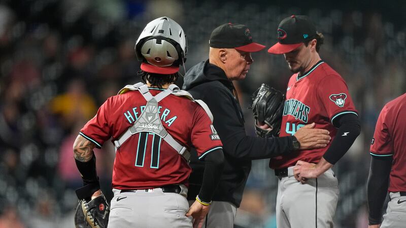 Arizona Diamondbacks pitching coach Brent Strom, center, confers with relief pitcher Blake...