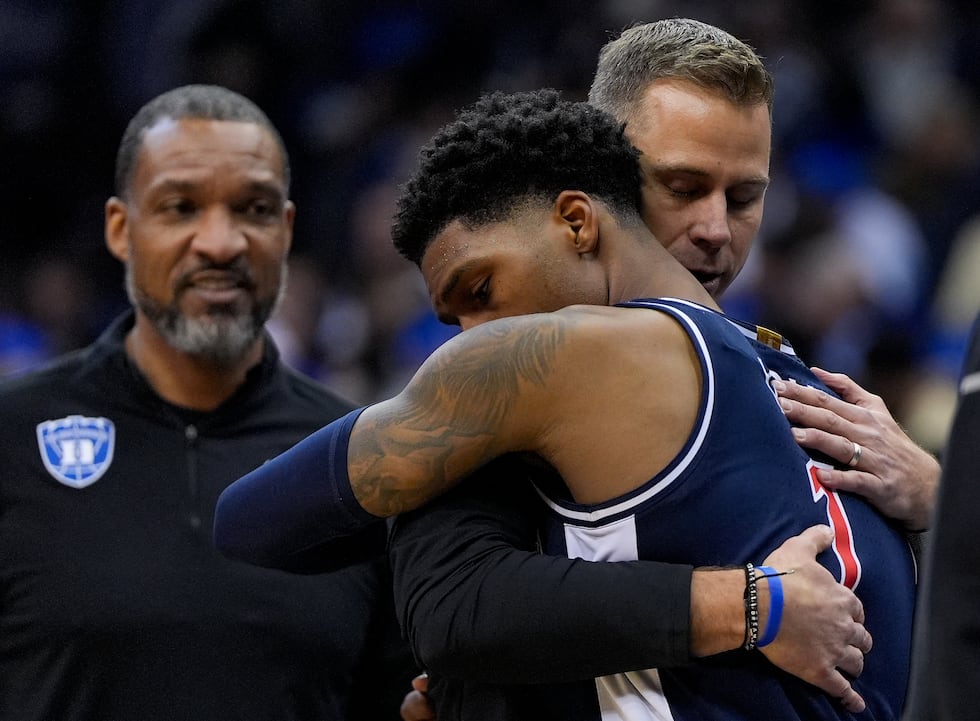 Arizona guard Caleb Love (1) hugs Duke head coach Jon Scheyer after Arizona lost to Duke in a...