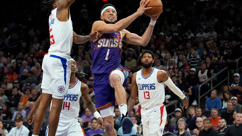 Phoenix Suns guard Devin Booker (1) drives past Los Angeles Clippers guard Bones Hyland, left,...