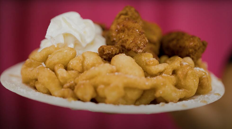 The Crispy Chicken Funnel Cake is made with savory fried chicken served on top of sweet funnel...