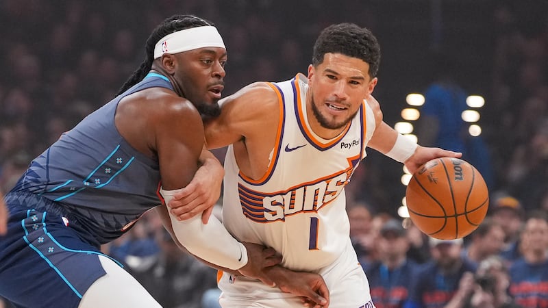 Phoenix Suns guard Devin Booker, right, drives past Oklahoma City Thunder guard Luguentz Dort...