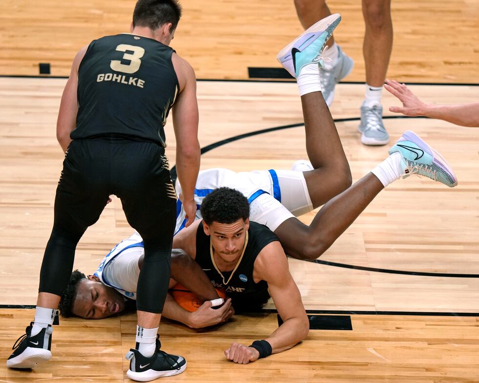 Oakland's Chris Conway, lower right, scrambles for the ball with Kentucky's Adou Thiero during...