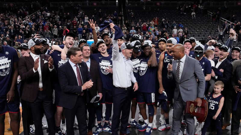 UConn head coach Dan Hurley, middle, celebrates with his team after the 82-54 win against...