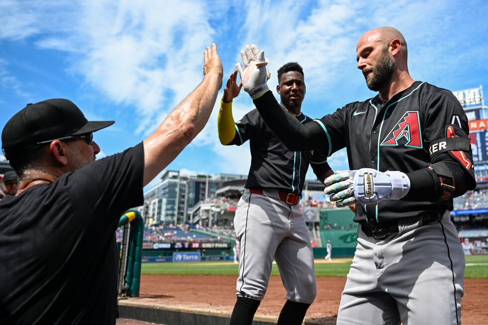 Arizona Diamondbacks manager Torey Lovullo, left, congratulates Diamondbacks' Christian Walker...