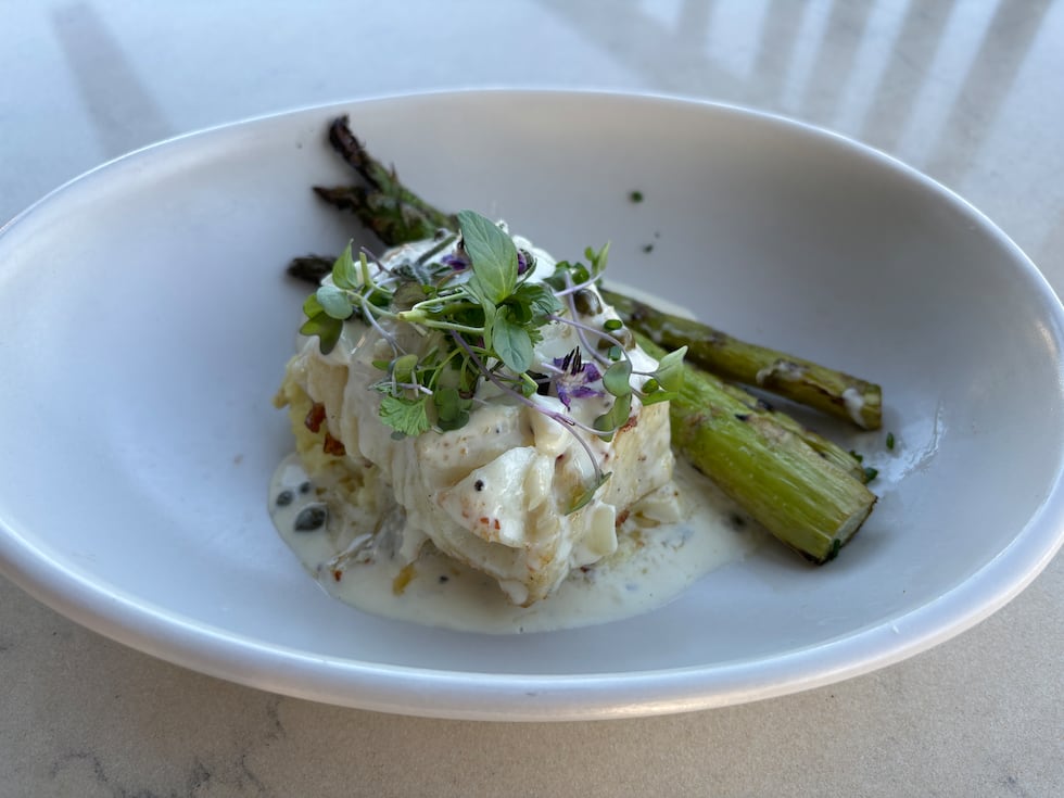 The Chilean Sea Bass is served with a wild mushroom risotto and grilled asparagus topped with...