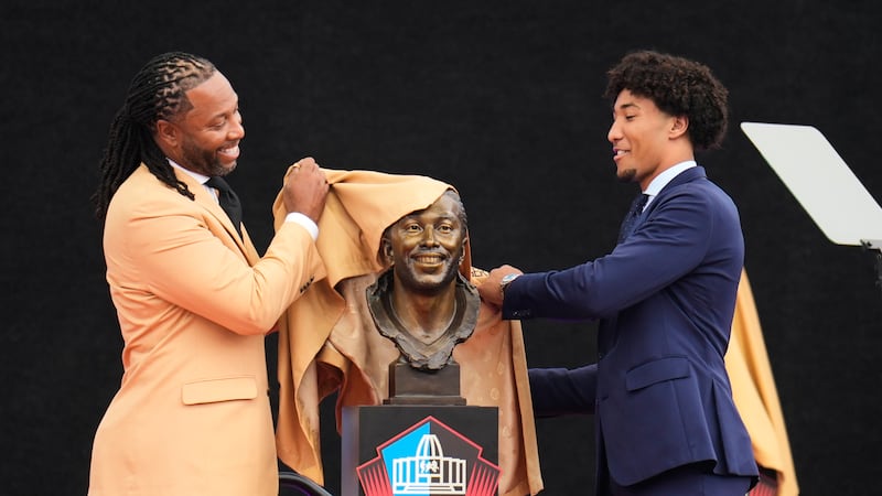 Former NFL player Larry Fitzgerald, left, unveils his bust with his son, Devin Fitzgerald,...