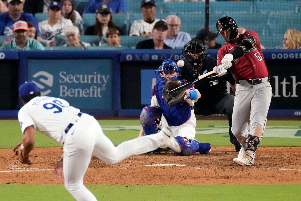 Arizona Diamondbacks' Christian Walker, right, hits a three-run home run as Los Angeles...