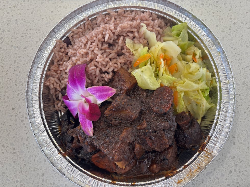 Seasoned Oxtail Entree with rice and peas, and cabbage.