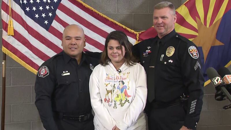 Aymee Ruiz was emotional as she embraced Chandler Officer Brian Larison (right) and Peoria...