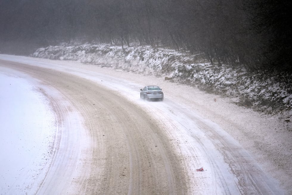 A car slowly navigates a snow-covered interstate on Sunday, Jan. 5, 2025, in St. Louis. (AP...