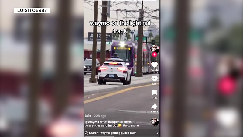 The self-driving car stopped on the tracks just before an oncoming light rail approached.