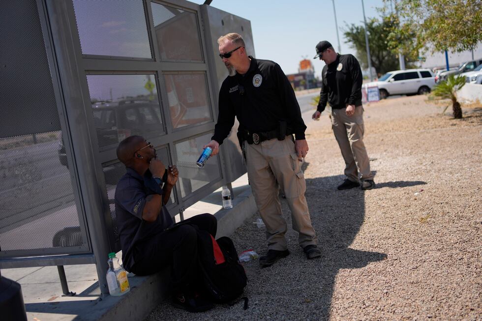 Mark Paulson, a Public Response and Code Enforcement officer, hands out cold water, Wednesday,...