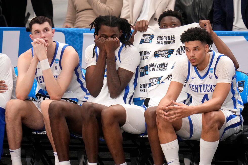 Players on the Kentucky bench watch late in the second half of the team's college basketball...